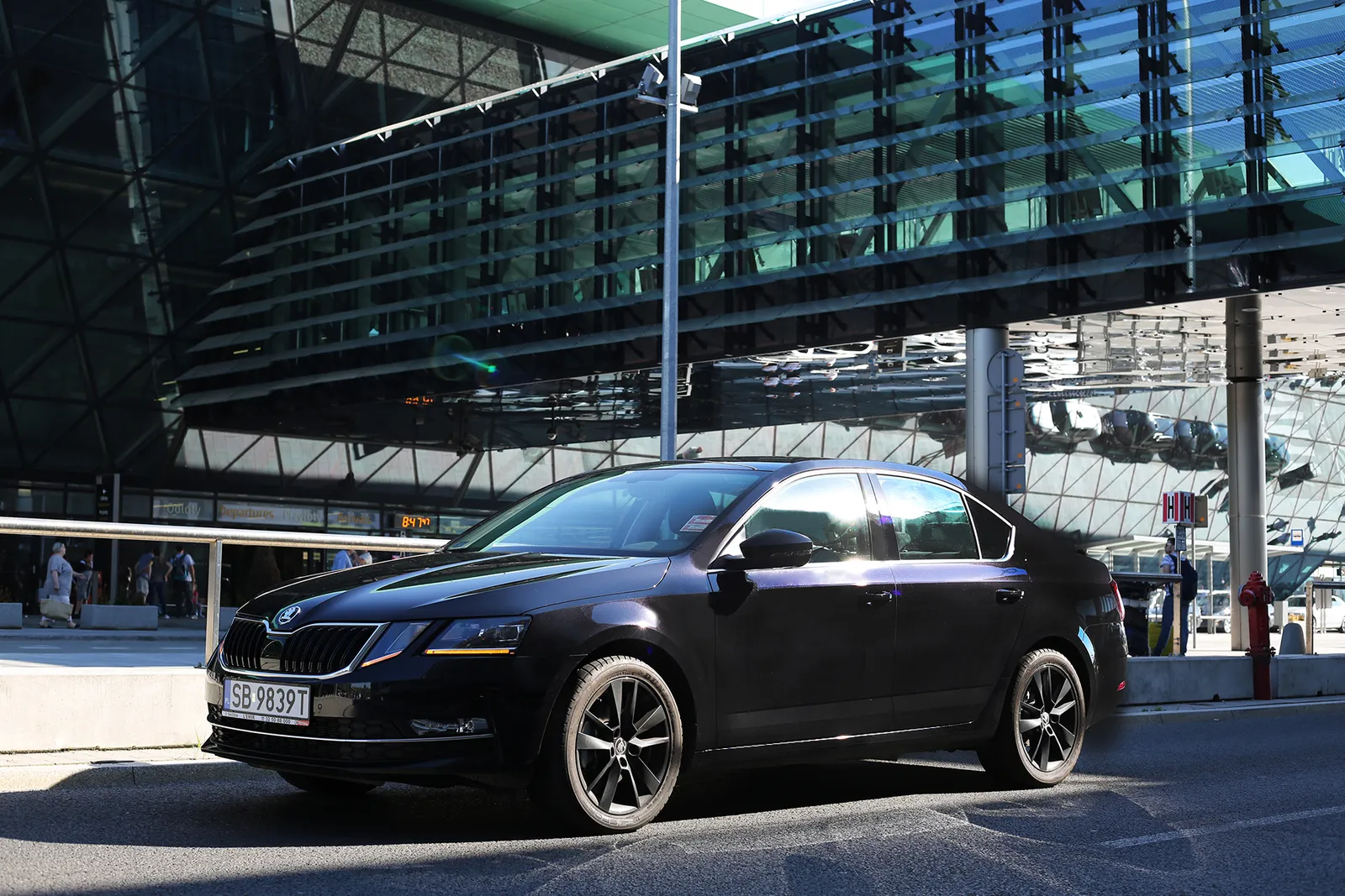 Czarna Skoda Octavia przed terminalem lotniska